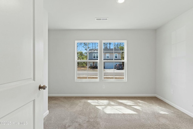 spare room with visible vents, baseboards, and carpet flooring