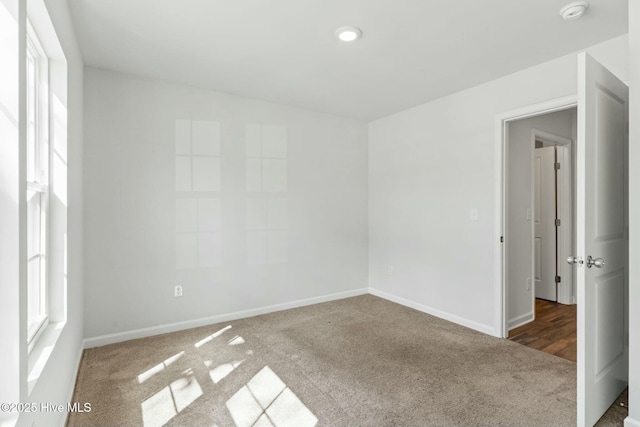 spare room with baseboards and carpet floors