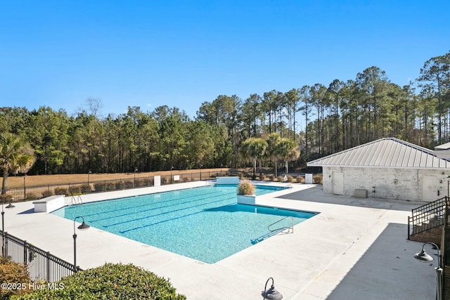 pool with a patio and fence