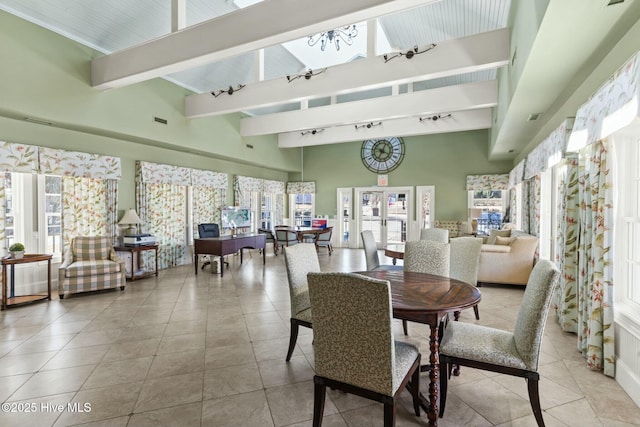 tiled dining room with visible vents, beam ceiling, a high ceiling, and rail lighting