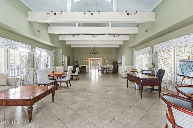 living area featuring beamed ceiling, a healthy amount of sunlight, and rail lighting
