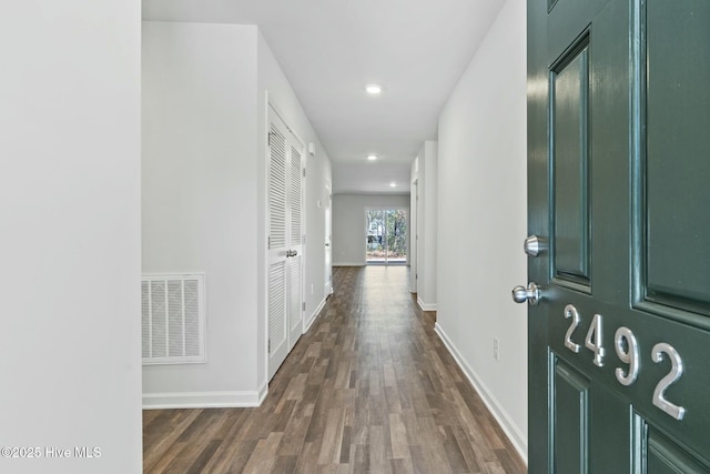 hall featuring dark wood finished floors, visible vents, recessed lighting, and baseboards
