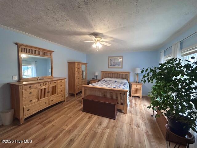 bedroom with a textured ceiling and light wood-style floors