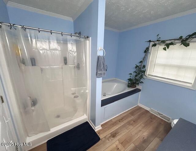 full bath with a shower with curtain, wood finished floors, visible vents, and a textured ceiling