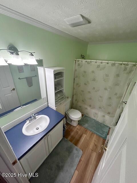 full bathroom featuring a textured ceiling, wood finished floors, vanity, and toilet