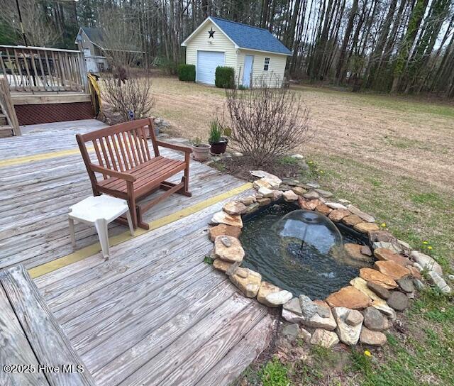 wooden terrace with an outbuilding and a hot tub