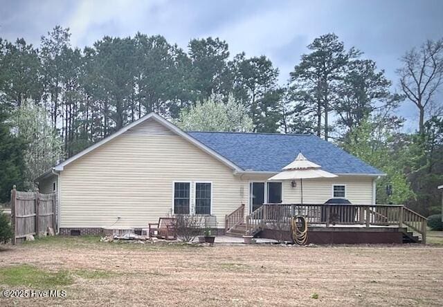 back of property featuring crawl space, a deck, and fence