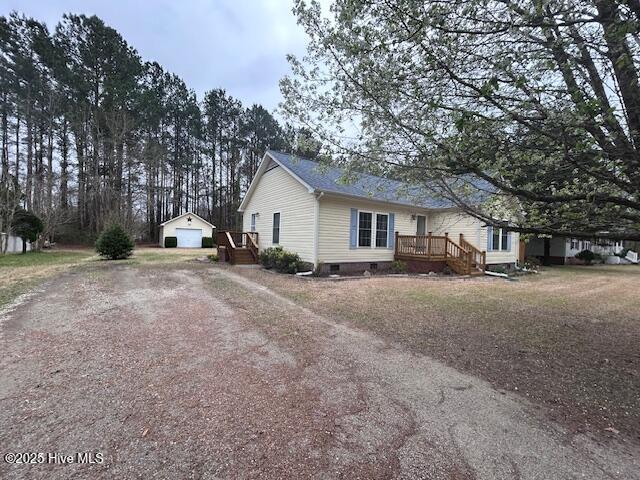 view of side of property featuring an outbuilding, driveway, a wooden deck, crawl space, and a detached garage