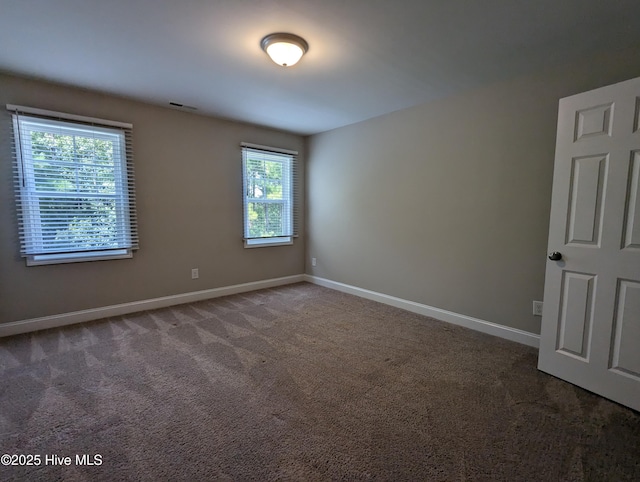 carpeted empty room with visible vents and baseboards