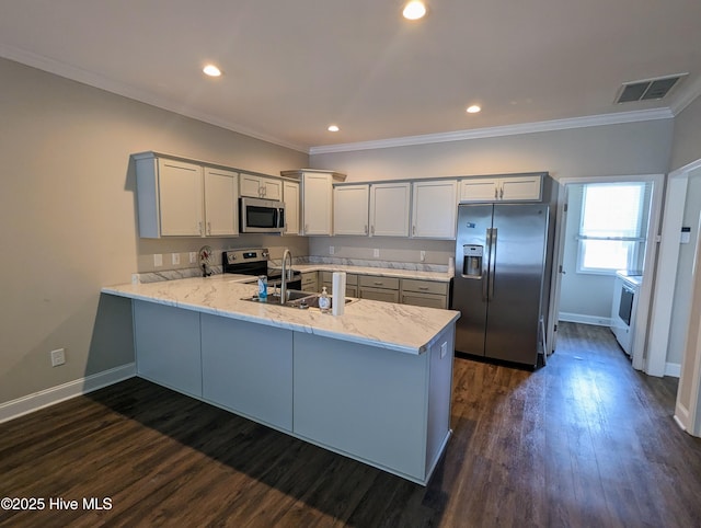 kitchen featuring a peninsula, baseboards, visible vents, and stainless steel appliances