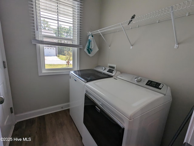 laundry area with laundry area, dark wood-type flooring, a wealth of natural light, and washing machine and clothes dryer