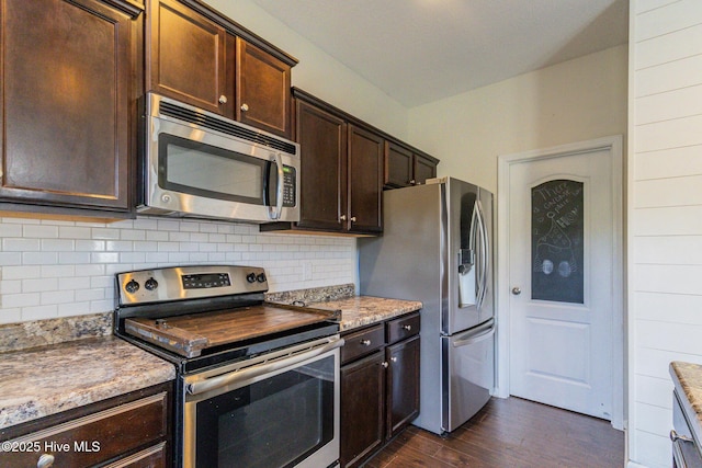 kitchen featuring dark wood-type flooring, light stone counters, stainless steel appliances, dark brown cabinetry, and decorative backsplash