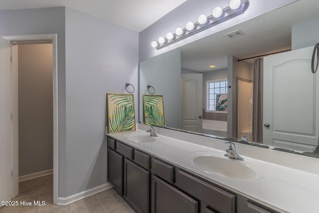 full bathroom featuring a sink, baseboards, double vanity, and tile patterned flooring