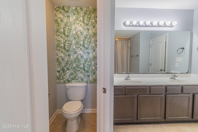 bathroom with tile patterned flooring, toilet, wallpapered walls, and a sink