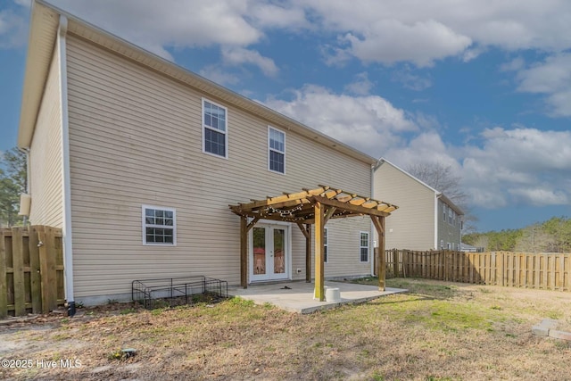 back of house with a lawn, a pergola, a patio, a fenced backyard, and french doors