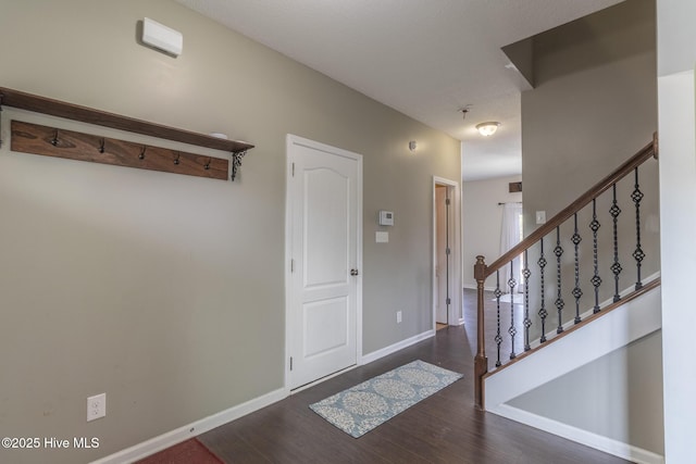 entryway featuring stairway, baseboards, and wood finished floors