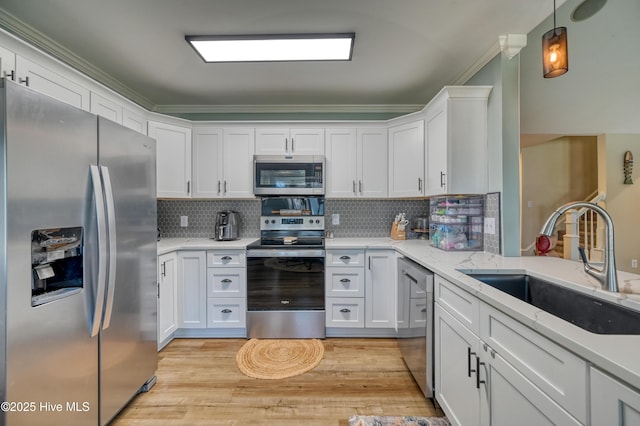 kitchen featuring a sink, white cabinets, light wood finished floors, and stainless steel appliances