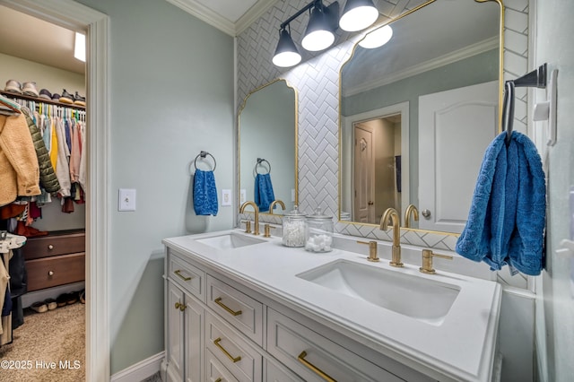 bathroom with crown molding, double vanity, baseboards, and a sink