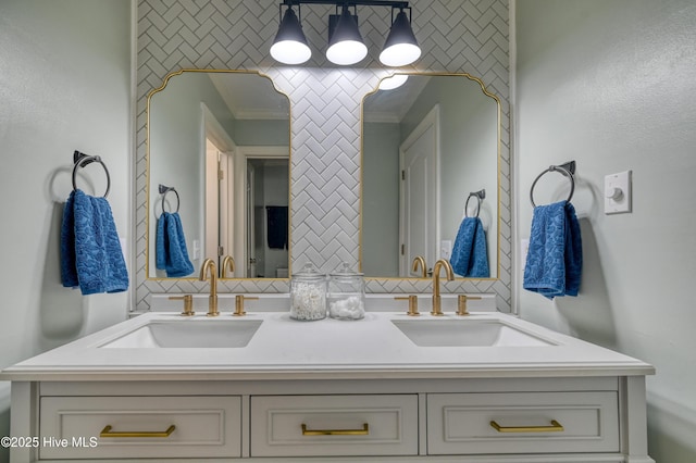 full bath with double vanity, crown molding, and a sink