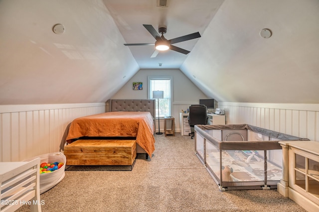 bedroom with carpet, wainscoting, a ceiling fan, and vaulted ceiling