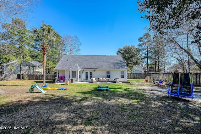 back of property with a fenced backyard, outdoor lounge area, a playground, and a trampoline