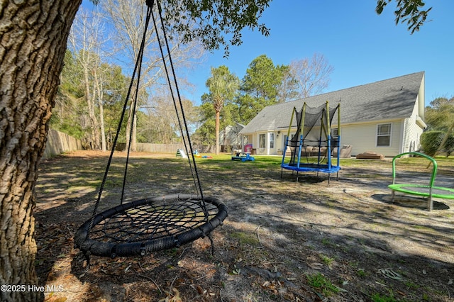 view of playground with a trampoline and fence