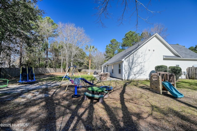 view of play area featuring a trampoline, a fenced backyard, and a yard