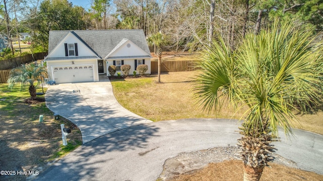 view of front of house with a garage, concrete driveway, and fence