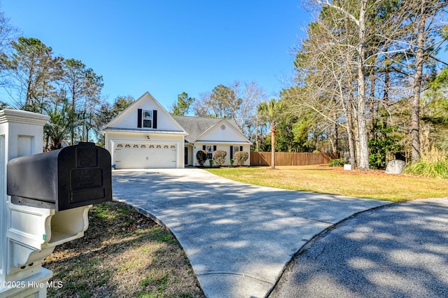 view of front facade featuring an attached garage, concrete driveway, a front lawn, and fence