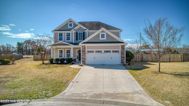 view of front of home with stone siding, driveway, a front yard, and fence