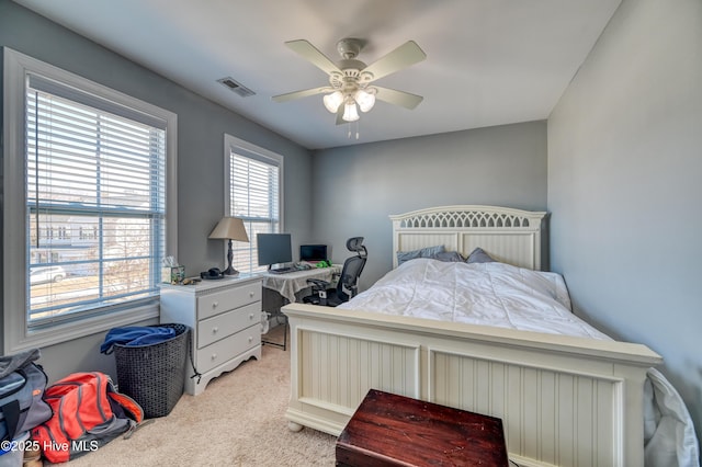 bedroom with visible vents, light carpet, and a ceiling fan