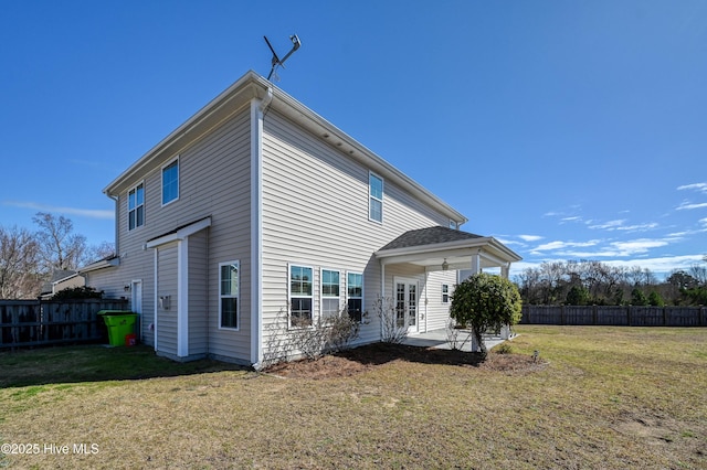 rear view of house with a patio area, a lawn, and fence