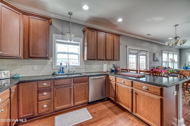 kitchen featuring ornamental molding, a peninsula, stainless steel dishwasher, brown cabinetry, and a sink