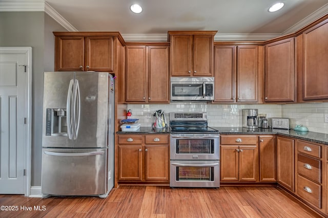 kitchen featuring stainless steel appliances, brown cabinets, and light wood finished floors