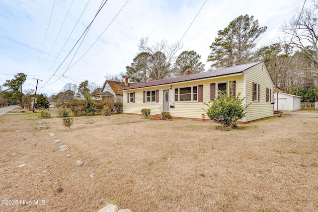 ranch-style house featuring metal roof and a front lawn