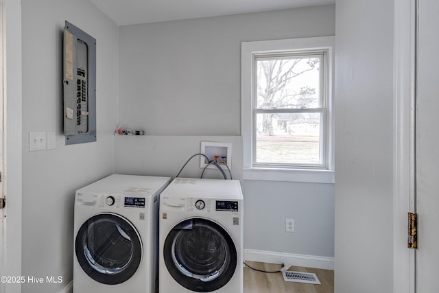 washroom featuring visible vents, baseboards, laundry area, wood finished floors, and washer and dryer