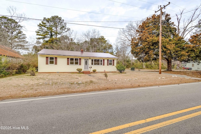 single story home with metal roof and entry steps