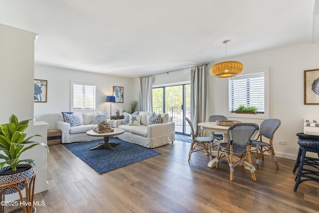 living room with a wealth of natural light, baseboards, and wood finished floors