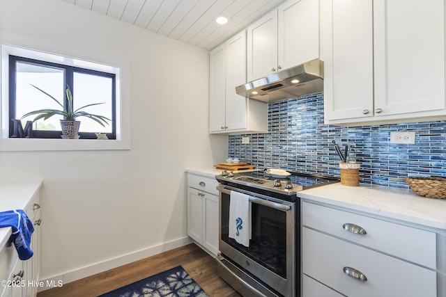 kitchen featuring baseboards, electric range, decorative backsplash, white cabinets, and under cabinet range hood