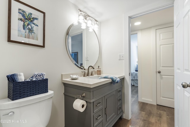 bathroom featuring recessed lighting, toilet, vanity, and wood finished floors