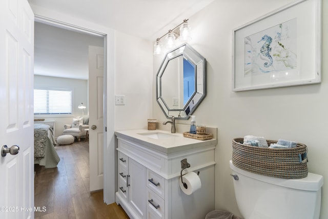 ensuite bathroom featuring ensuite bathroom, toilet, wood finished floors, and vanity