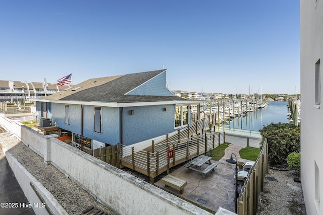 exterior space featuring central AC and a water view