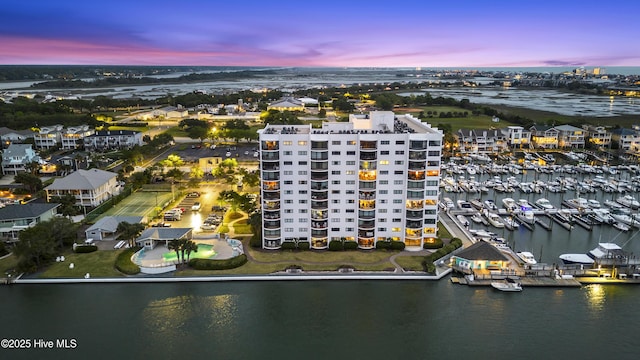 aerial view at dusk featuring a water view