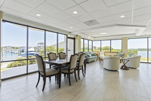 dining space featuring recessed lighting, a paneled ceiling, and a water view