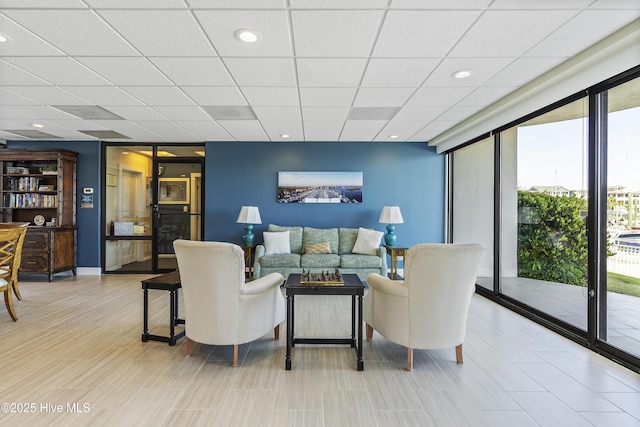 living room featuring expansive windows, recessed lighting, and a paneled ceiling