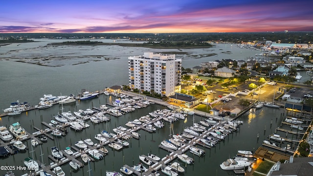 aerial view at dusk featuring a water view