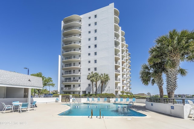 community pool featuring a patio and fence