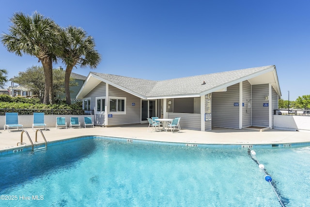 community pool with a patio and fence