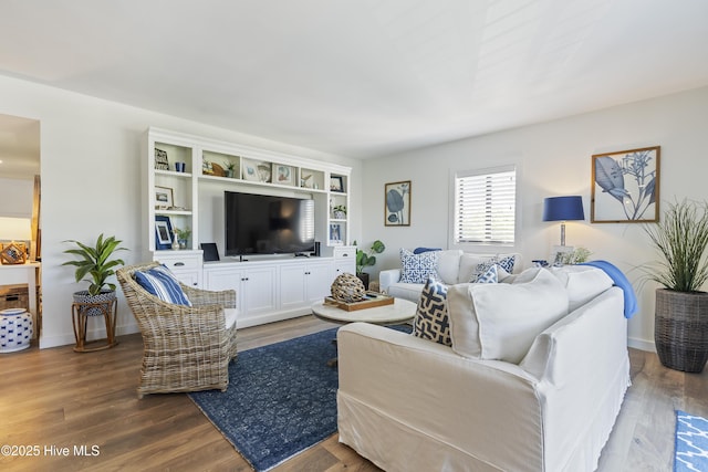 living area featuring baseboards and wood finished floors