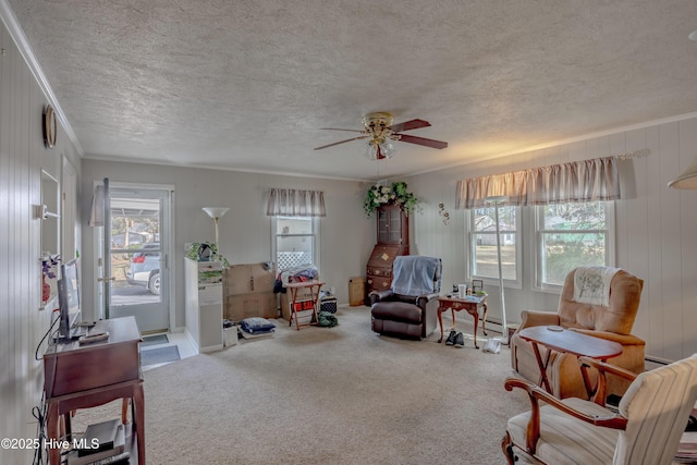 sitting room with a textured ceiling, crown molding, a ceiling fan, and carpet floors